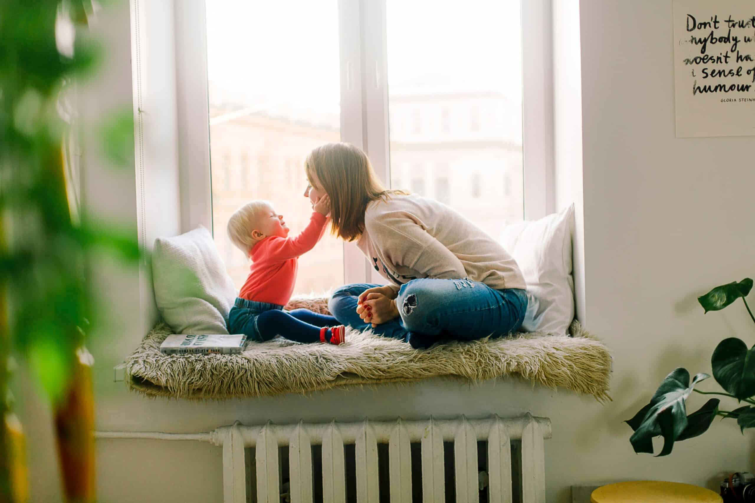 A young mom is playing with her baby at home.
